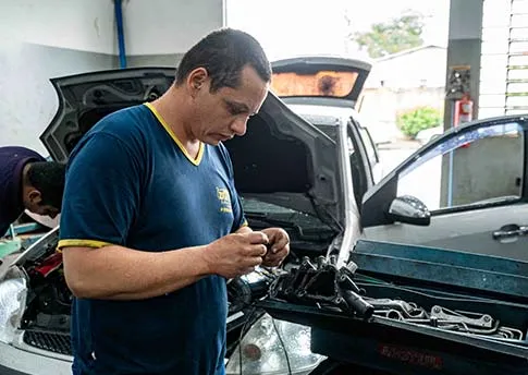 Mecânico especialista reparando motor de carro na Dacar Presidente Prudente