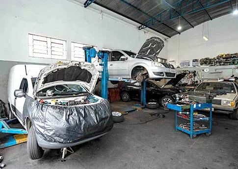 Carros em manutenção no interior da Mecânica Dacar