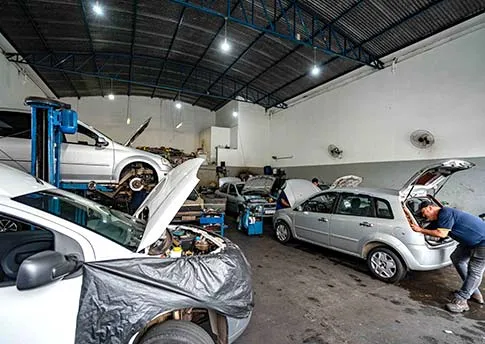 Equipe trabalhando em veículos na oficina Dacar